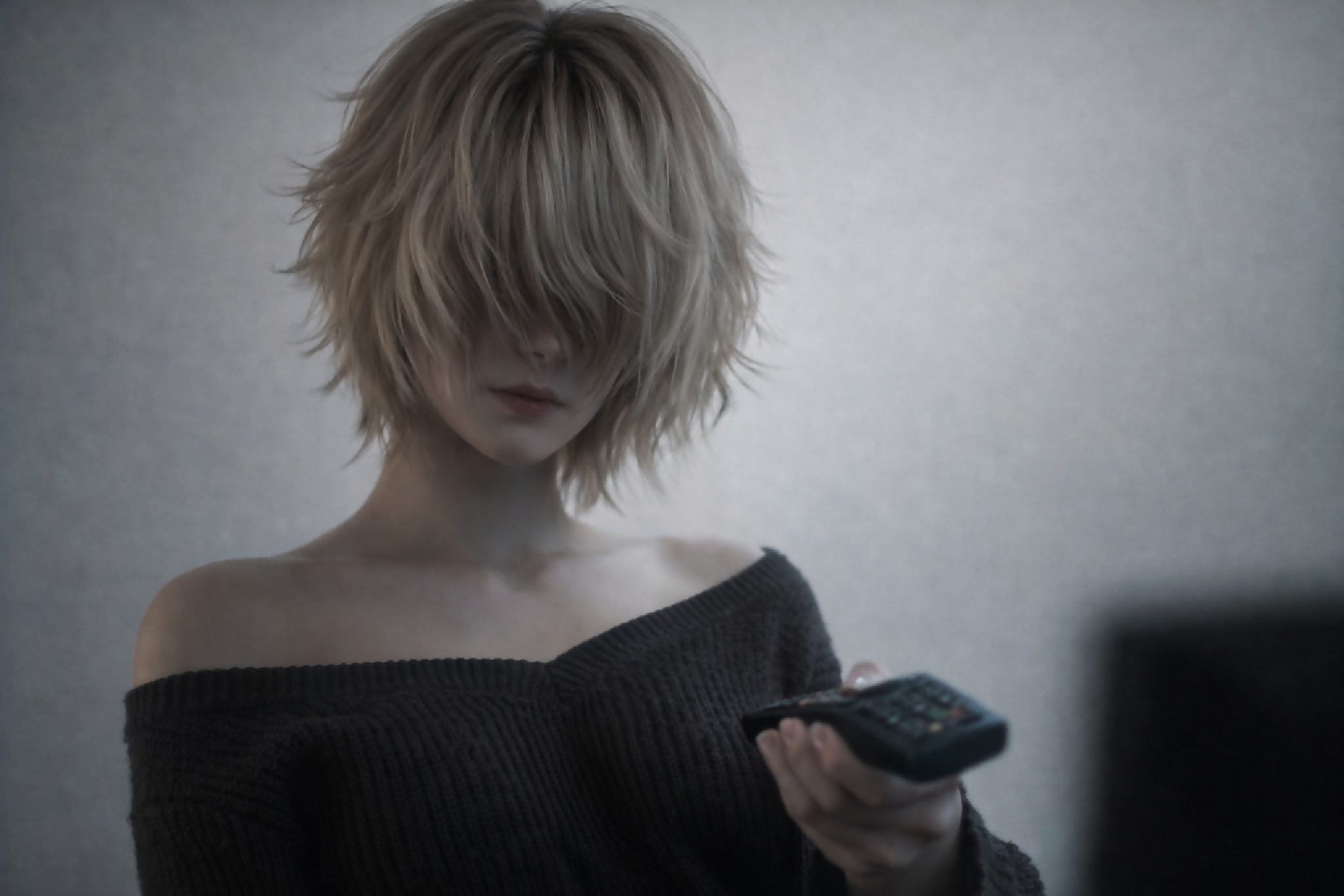 A minimalist, moody portrait of a mysterious young woman watching TV